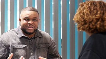 A man discusses cybersecurity strategies in a modern office, reflecting digital protection and risk awareness. A man discusses cybersecurity strategies in a modern office, reflecting digital protection and risk awareness.